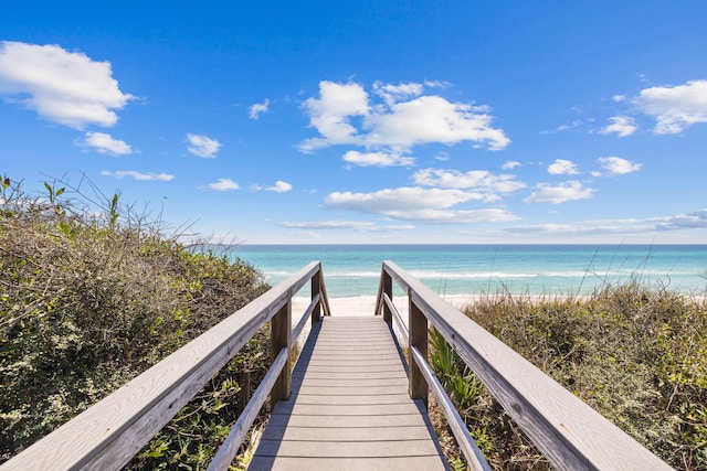 surrounding community featuring a water view and a beach view