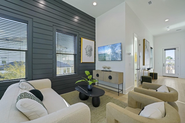 living room featuring wood walls and light wood-type flooring