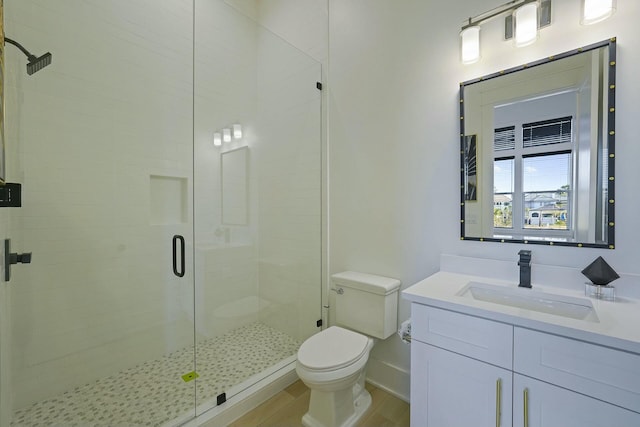 bathroom with a shower with door, toilet, and vanity