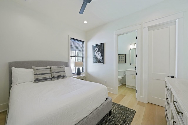 bedroom with ceiling fan, light hardwood / wood-style flooring, and ensuite bath