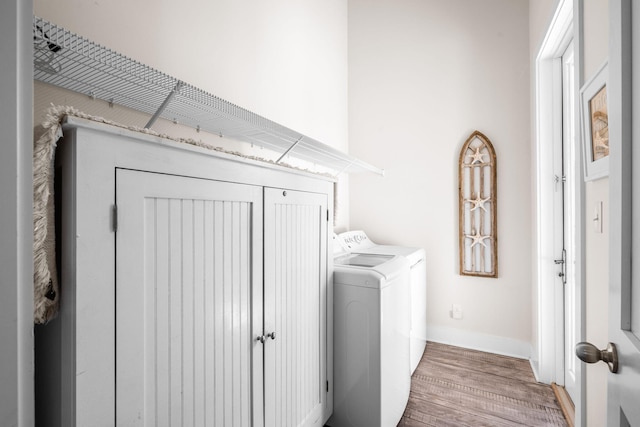 laundry room with washer and dryer and hardwood / wood-style flooring