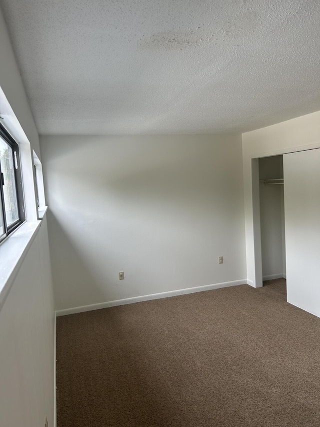 interior space with carpet floors and a textured ceiling