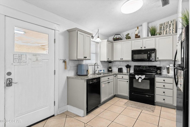 5620 Pinetree Ave, Panama City Beach, FL 32408 - kitchen with light tile patterned floors, sink, tasteful backsplash, black appliances, and vaulted ceiling