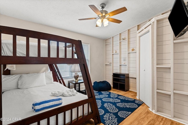 5620 Pinetree Ave, Panama City Beach, FL 32408 - bedroom featuring ceiling fan, hardwood / wood-style flooring, and a textured ceiling