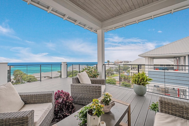 balcony featuring a water view and an outdoor living space