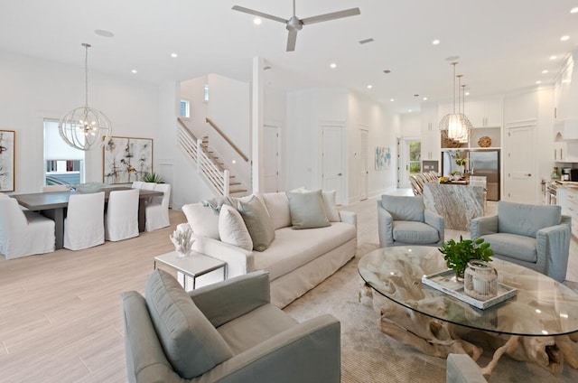 living room with ceiling fan with notable chandelier