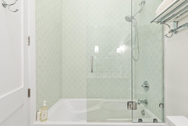 bathroom featuring bath / shower combo with glass door and toilet