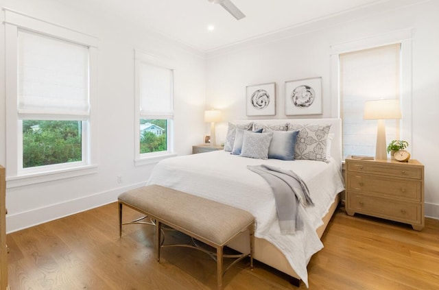 bedroom featuring ceiling fan, ornamental molding, and light wood-type flooring