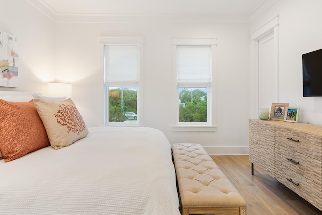 bedroom with crown molding and light hardwood / wood-style flooring