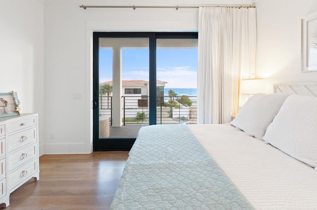 bedroom featuring a water view and light wood-type flooring