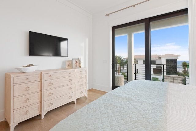 bedroom featuring light wood-type flooring, access to exterior, and crown molding