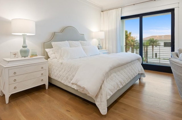 bedroom with access to outside and hardwood / wood-style flooring