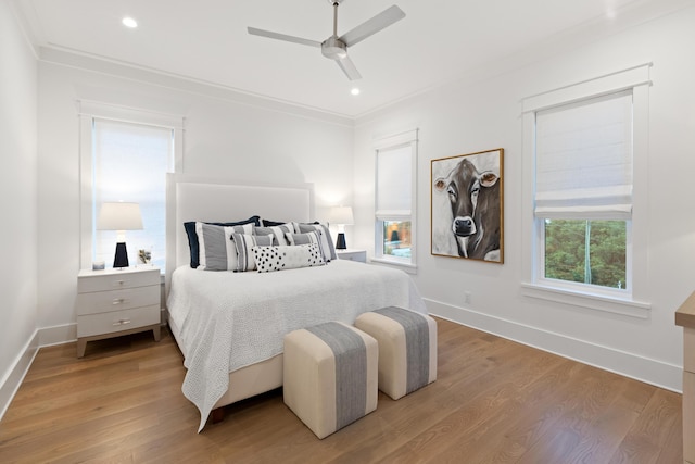 bedroom with ceiling fan, hardwood / wood-style flooring, and crown molding