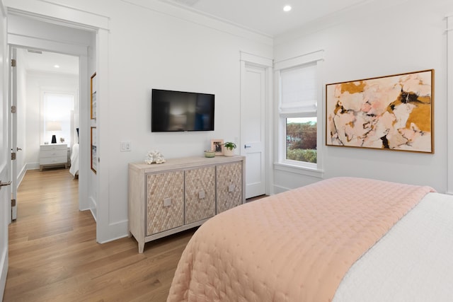 bedroom with hardwood / wood-style floors and crown molding