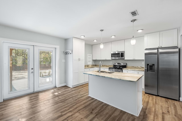 kitchen with white cabinetry, appliances with stainless steel finishes, sink, and decorative light fixtures