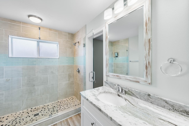 bathroom with vanity, hardwood / wood-style flooring, and a shower with door