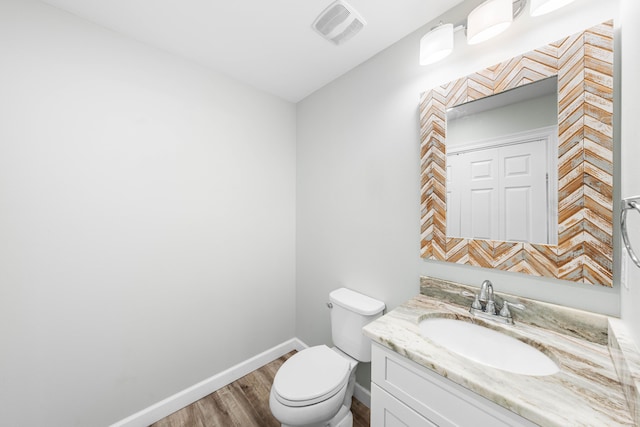 bathroom with hardwood / wood-style flooring, vanity, and toilet