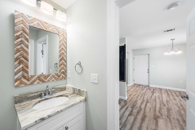 bathroom with vanity, wood-type flooring, and a chandelier