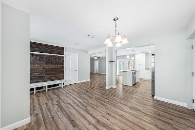 unfurnished living room featuring ceiling fan with notable chandelier, sink, and light hardwood / wood-style floors