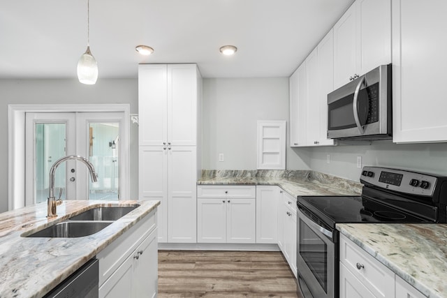 kitchen featuring stainless steel appliances, sink, hanging light fixtures, and white cabinets