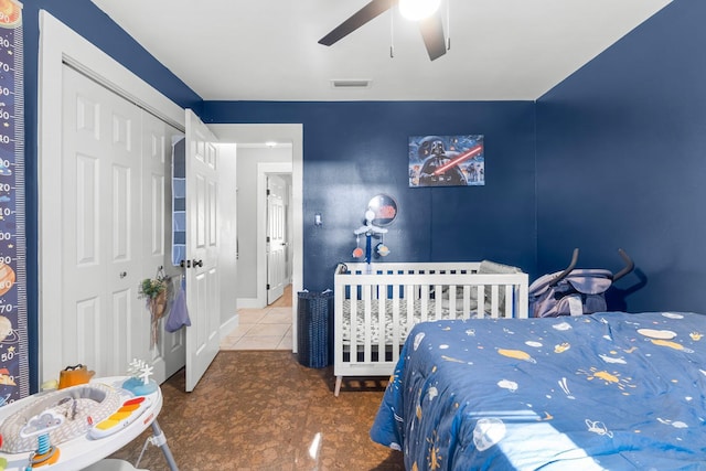 bedroom with tile patterned floors, a closet, and ceiling fan