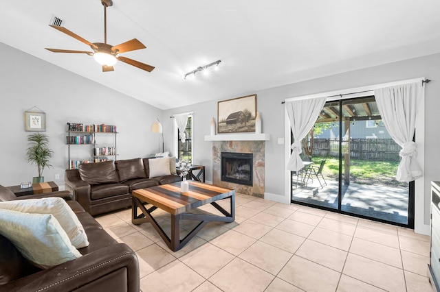 living room featuring lofted ceiling, light tile patterned floors, ceiling fan, and a fireplace