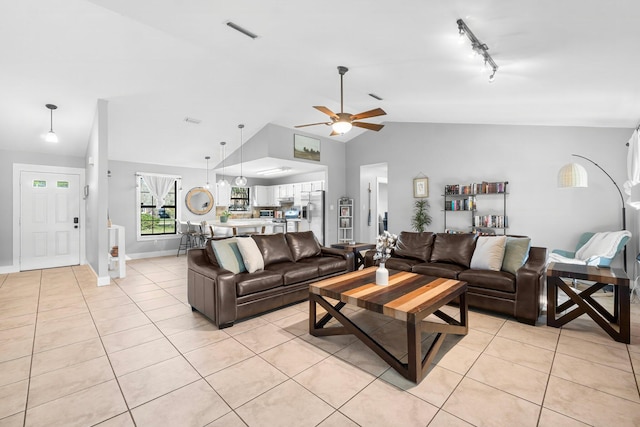 living room with light tile patterned floors, ceiling fan, rail lighting, and lofted ceiling