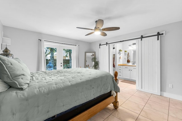 bedroom with french doors, a barn door, access to exterior, sink, and light tile patterned floors