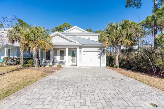 view of front of property featuring a front lawn, a garage, and covered porch