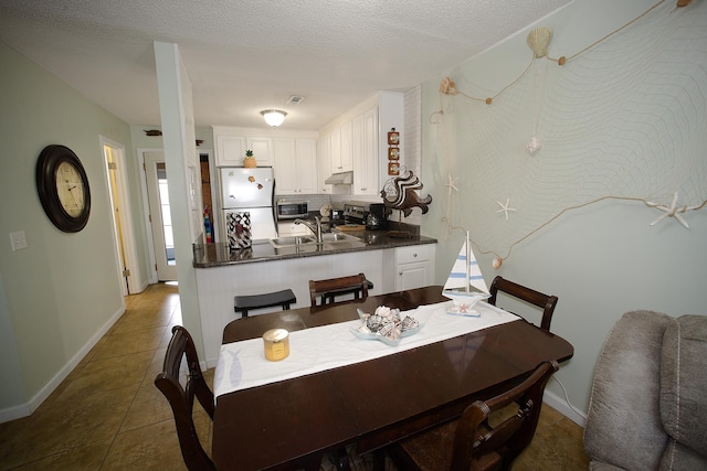 dining area featuring dark tile patterned flooring and sink