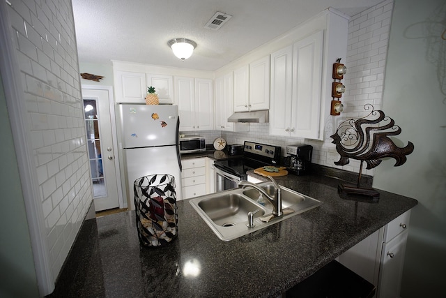 kitchen featuring appliances with stainless steel finishes, white cabinetry, sink, backsplash, and kitchen peninsula