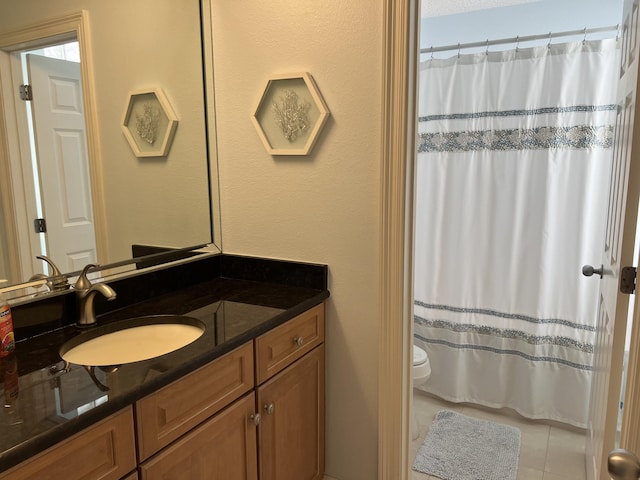 bathroom featuring vanity, tile patterned floors, toilet, and walk in shower