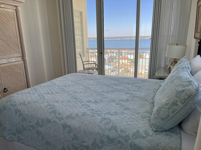 bedroom featuring a water view and access to outside