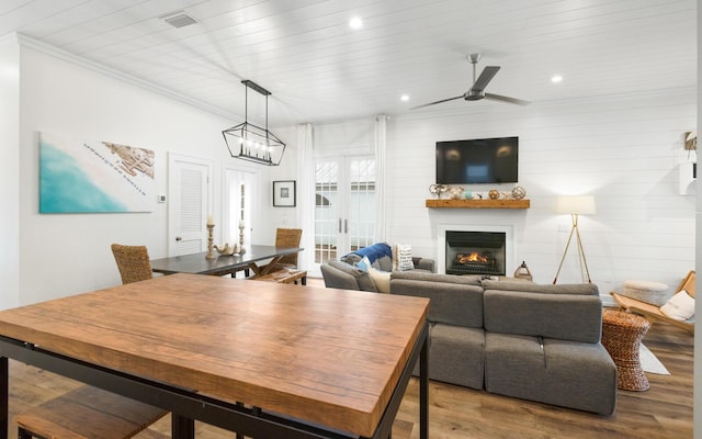 dining space with wooden ceiling, ornamental molding, hardwood / wood-style flooring, ceiling fan, and a fireplace