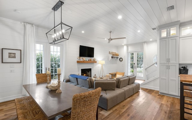 dining space with french doors, ornamental molding, light hardwood / wood-style flooring, and wooden ceiling