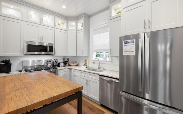 kitchen with sink, white cabinets, stainless steel appliances, light stone countertops, and wooden ceiling