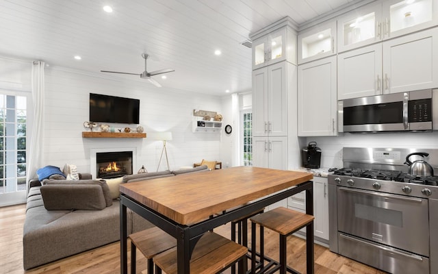 kitchen with stainless steel appliances, wooden ceiling, white cabinets, and light wood-type flooring