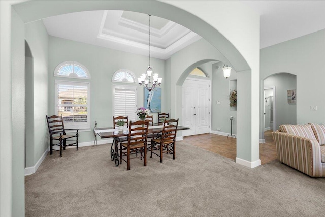 dining space with a high ceiling, an inviting chandelier, and light carpet