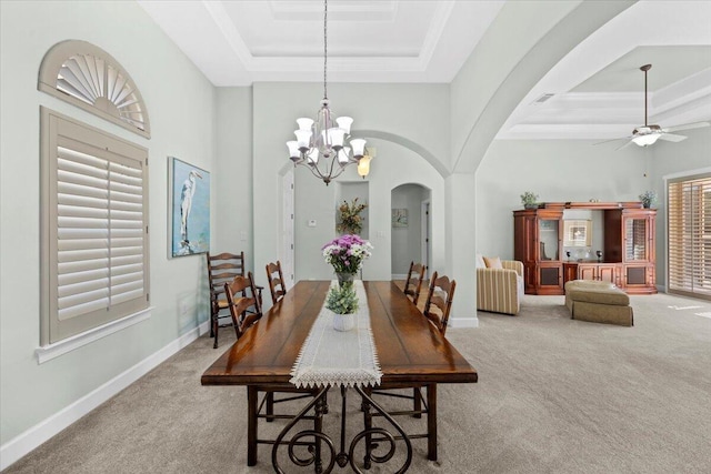 carpeted dining area featuring a high ceiling, a wealth of natural light, and a raised ceiling