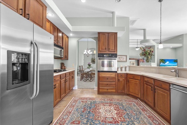 kitchen with decorative light fixtures, sink, a notable chandelier, and appliances with stainless steel finishes