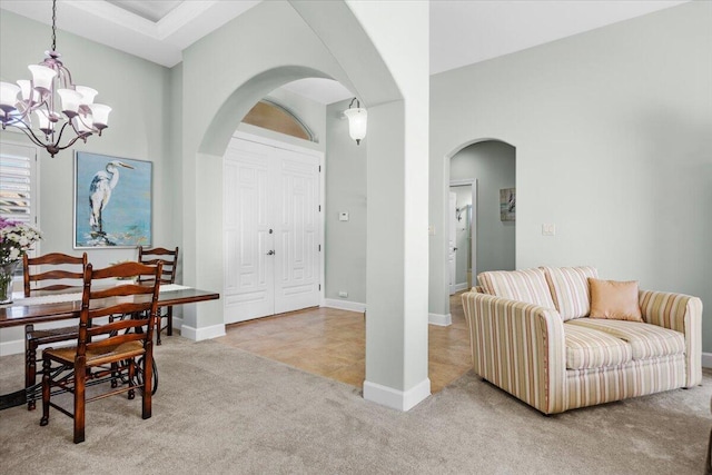 interior space featuring a chandelier, a high ceiling, and light carpet