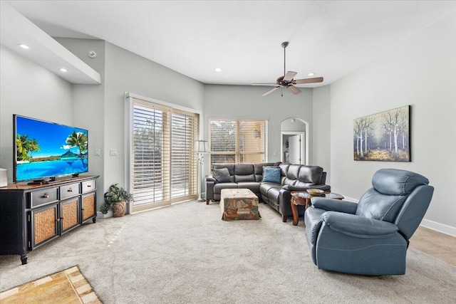 living room with carpet floors, a towering ceiling, and ceiling fan