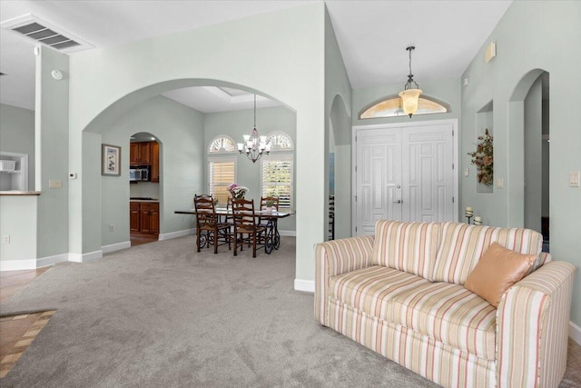 carpeted living room featuring a towering ceiling