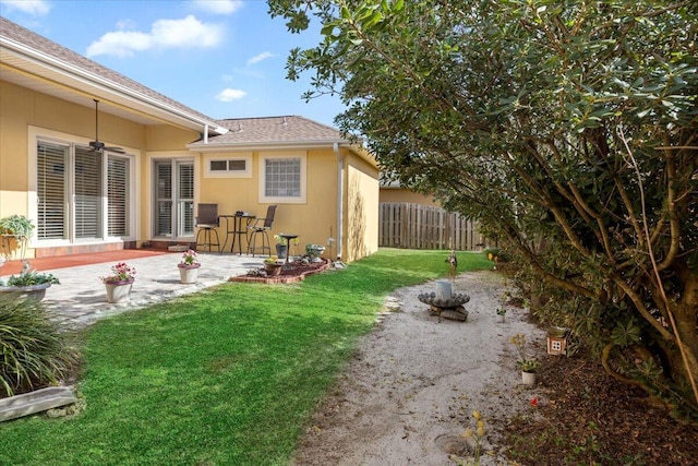 view of yard with ceiling fan and a patio area