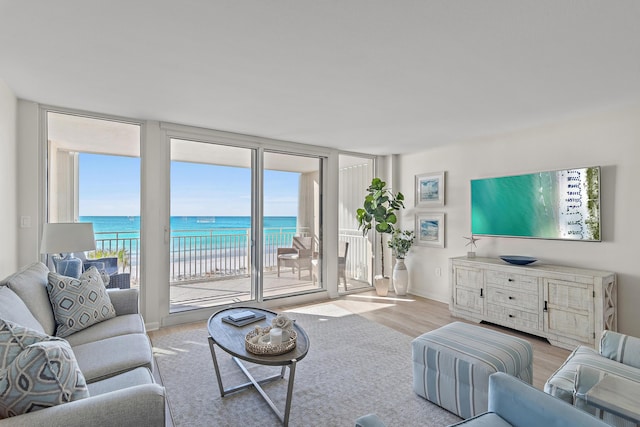 living room featuring expansive windows, a water view, and plenty of natural light