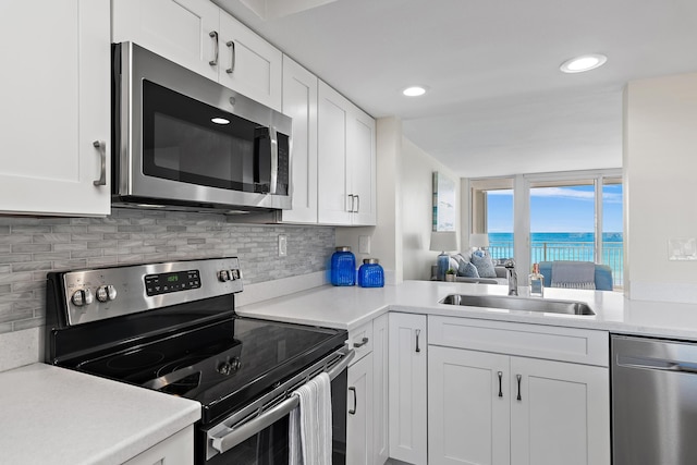 kitchen featuring tasteful backsplash, appliances with stainless steel finishes, sink, and white cabinets