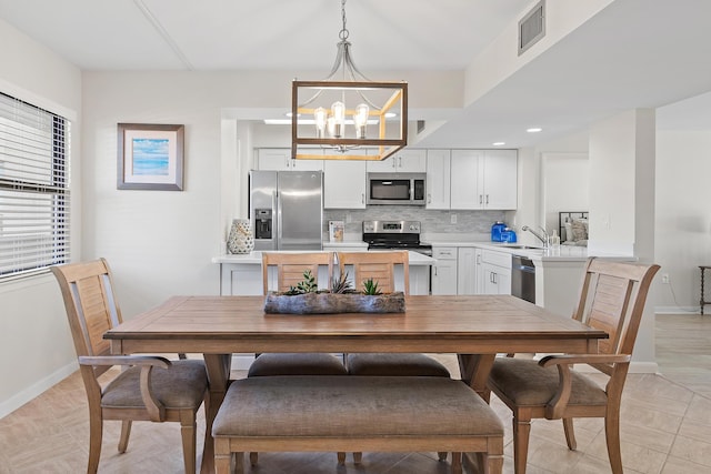 dining room with a notable chandelier and sink