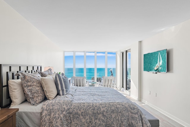 bedroom featuring hardwood / wood-style flooring and expansive windows