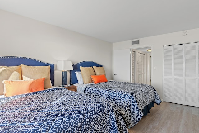 bedroom with wood-type flooring and a closet