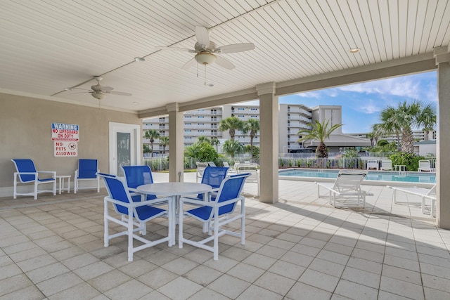 view of patio with ceiling fan and a community pool